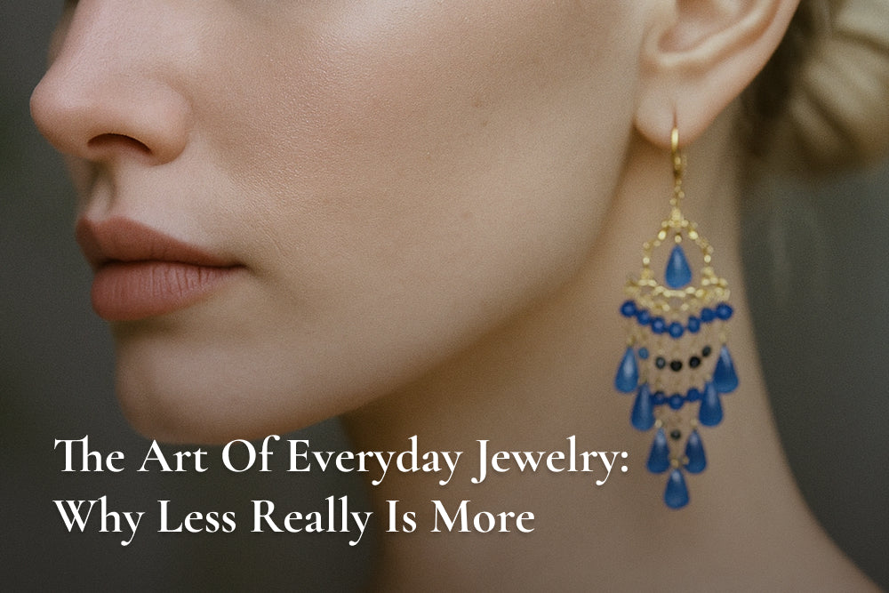 Close-up of an ear adorned with a gold earring featuring blue teardrop gems and black accents, showcasing minimalist elegance from Minika Jewelry's everyday jewelry collection.